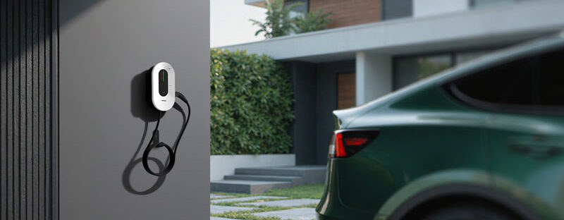 EV charger mounted on a wall beside an electric car
