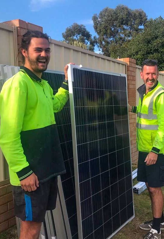 Green Sun Solutions team members holding a solar panel during installation